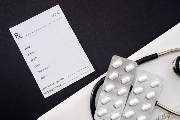 笔记本电脑是听诊器药丸和一个经验丰富的医生处方站在黑色背景图片下载