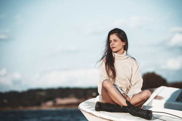 年轻漂亮的女人坐在船上做着白日梦图片下载
