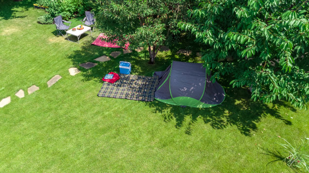 从上面鸟瞰营地，在树下的帐篷和露营设备，在户外露营的家庭度假概念图片下载
