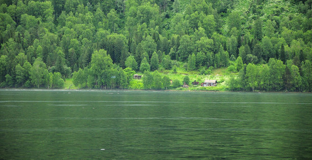 一座古老的小木屋，坐落在美丽的湖边的森林边缘。图片下载