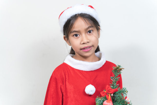 亚洲小女孩身着红色圣诞老人套装在家庆祝圣诞节。圣诞假期概念股票照片图片下载