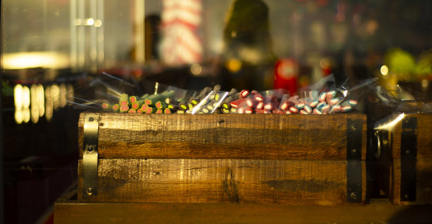 玻璃柜台上有一个木盒，里面装着色彩鲜艳的果酱糖果。图片下载
