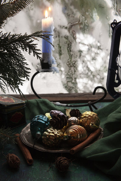 以燃烧的蜡烛和雪白的窗户为背景的静物画图片下载