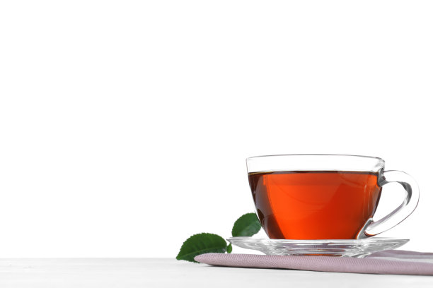 在白色的背景下，桌上放着一杯芳香的红茶和绿叶。空间的文本图片下载