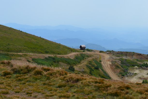 乡间小路旁的山上有一座小木屋图片下载