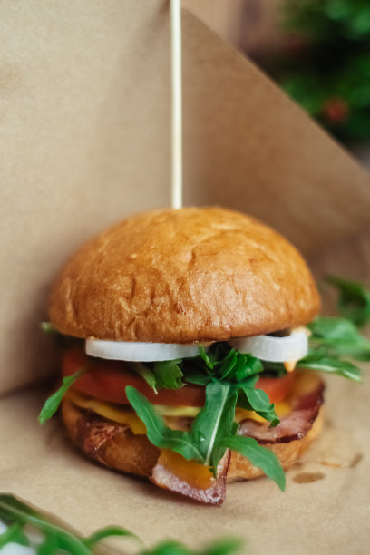 一个标准汉堡的特写镜头。餐馆或咖啡馆里的成人快餐。微距照片的汉堡原料与肉，奶酪和香草。为全家准备的环保汉堡图片下载