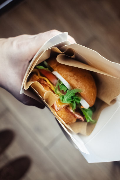 一个标准汉堡的特写镜头。餐馆或咖啡馆里的成人快餐。微距照片的汉堡原料与肉，奶酪和香草。为全家准备的环保汉堡图片下载