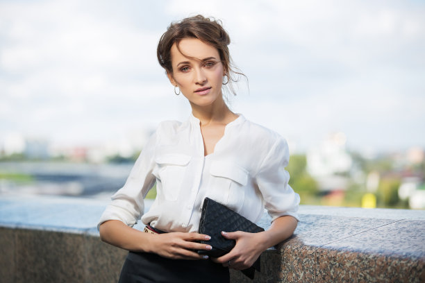 年轻时尚的商业妇女在白色衬衫与手包图片下载