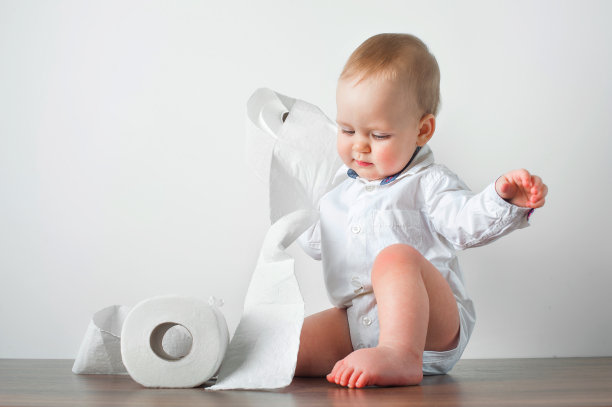 漂亮的金发小孩穿着衬衫和卫生纸卷马桶。如厕训练……图片下载