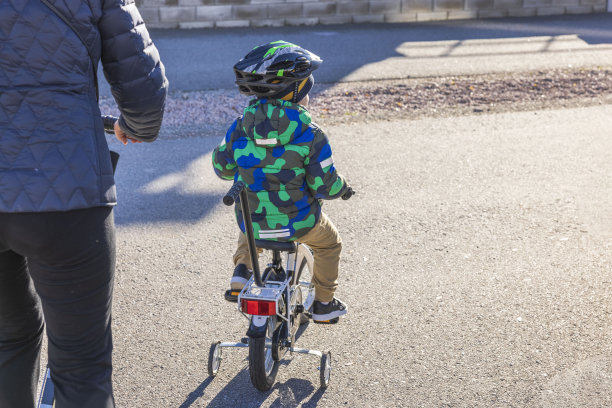 秋日，孩子在人行道上骑自行车的美丽景象。瑞典。图片下载