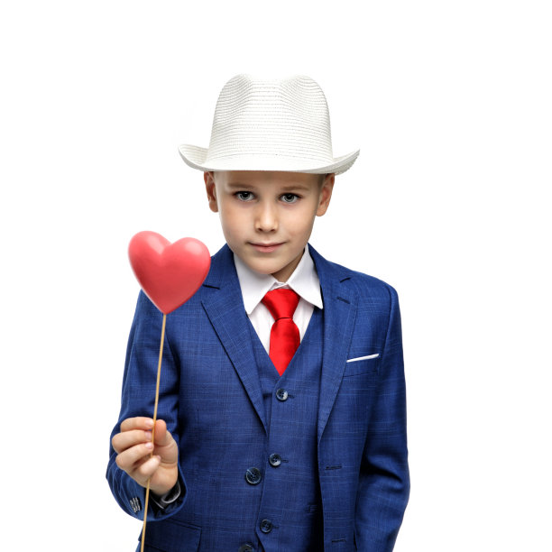 穿着西装，手里拿着情人节礼物的可爱男孩图片下载