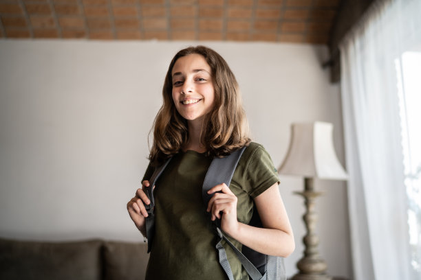 一个十几岁的女学生的肖像与背包在家里图片下载