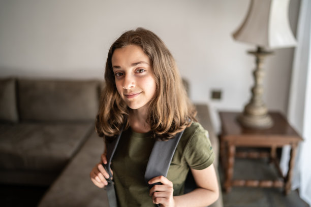 一个十几岁的女学生的肖像与背包在家里图片下载