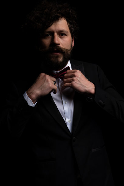 年轻性感的商人正在整理他的领结图片下载