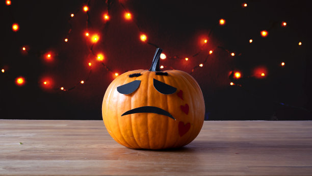 南瓜灯在木桌上哭泣。每边都有可用的拷贝空间。图片下载