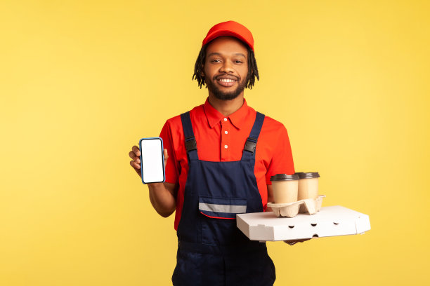 穿着工装裤的快递员拿着咖啡杯，手机上有模拟显示屏，网上订购服务图片下载
