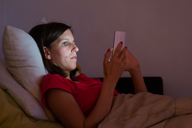 坐在沙发上玩手机的女人图片下载