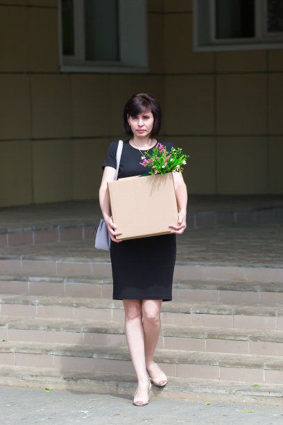 沮丧的被解雇的黑发会计离开大楼与一箱个人物品图片下载