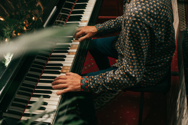 成年男性的手在钢琴或三角钢琴的琴键上弹奏旋律图片下载