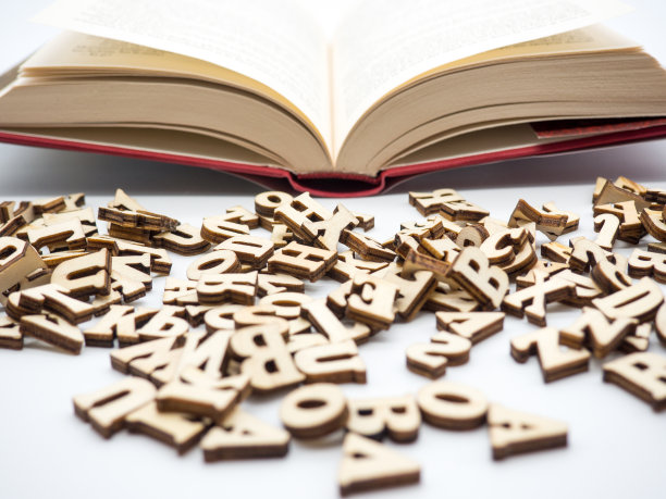 木制的字母在一排书旁边展开，概念性的照片图片下载