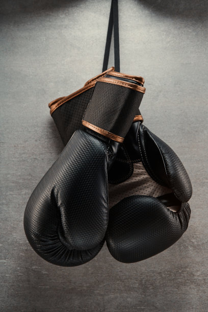 在黑暗的环境中，一副拳击手套挂在混凝土墙上图片下载