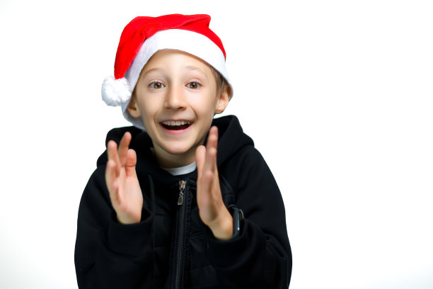 一个白色背景上戴着圣诞老人帽子的男孩图片下载