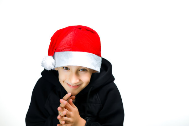 一个白色背景上戴着圣诞老人帽子的男孩图片下载