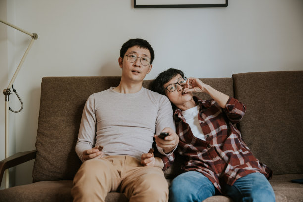 亚宁静的儿子和年长的母亲在假日里一起吃巧克力和看电视的照片图片下载