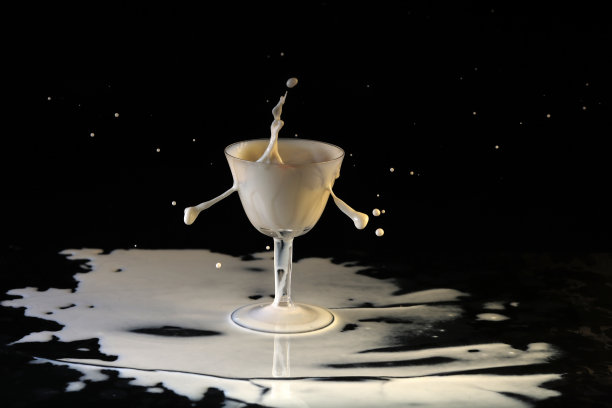 牛奶从玻璃高脚杯中溅了出来图片下载