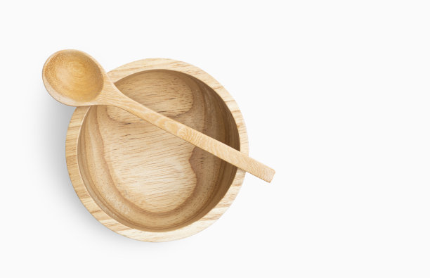 孤立的空木碗和勺子在白色的背景，接近，俯视图图像的碗勺子在碗。木碗自然线条图案，锉削路径。图片下载