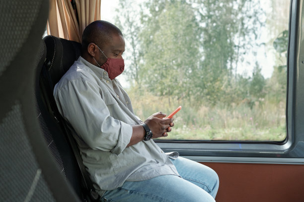 年轻的当代男子戴着防护面具在手机上滚动图片下载