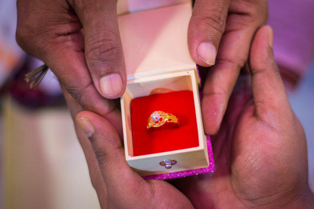 婚礼当天，新娘的父亲将金戒指交给新郎手的特写镜头图片下载