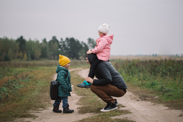 幸福的一家人带着两个孩子在秋天的田野里散步。图片下载