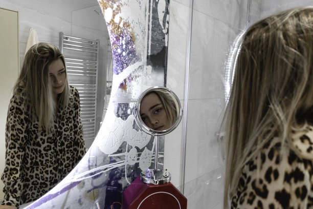 一个女孩映照在浴室的两面镜子里图片下载