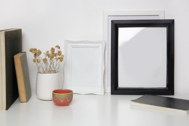 木制框架模型桌上与家庭室内装饰元素。书，陶瓷杯和干花中性调色板。白墙的背景。图片下载