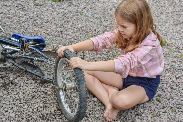 一个小女孩损坏了一个自行车轮子，正在修理照片没有处理图片下载