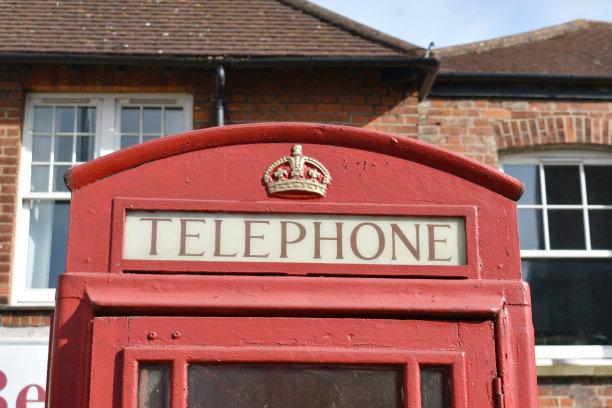 老式红色电话亭的特写，上面有金色的皇冠，图片下载