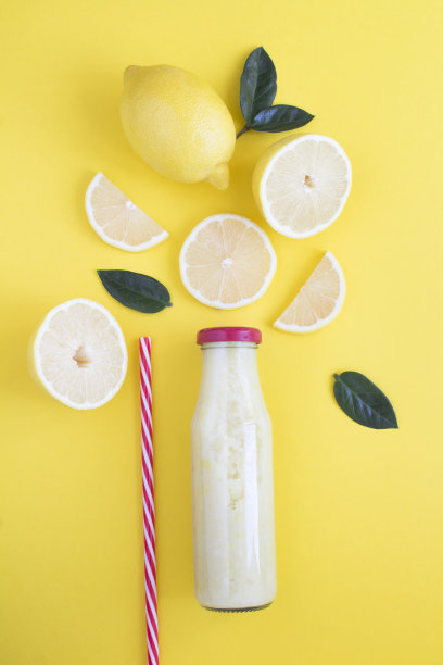 俯视图柠檬冰沙在一个玻璃瓶在黄色的背景。特写镜头。图片下载