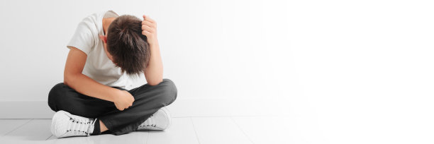 一个沮丧的孩子坐在地板上图片下载