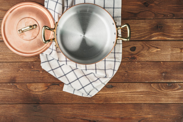 木桌上全新的铜锅，从上往下看图片下载