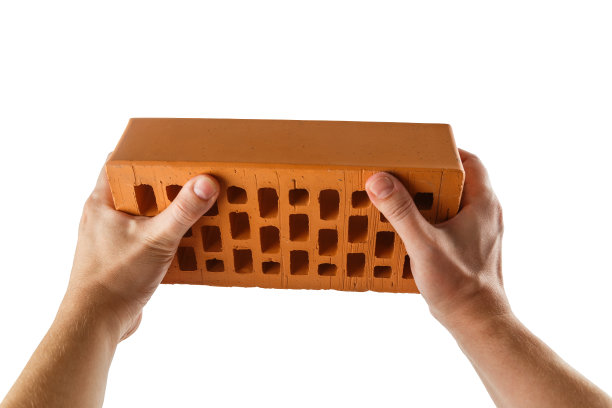 两只白种人裸露的手拿着橙色的多孔粘土砖-隔离在白色上图片下载