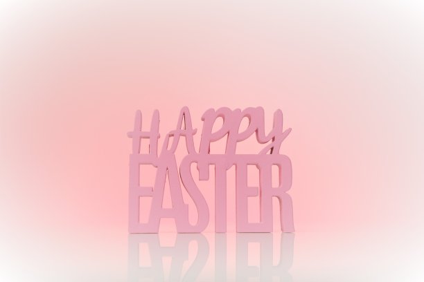 复活节假期。粉红色背景上的复活节快乐题词。宗教节日的背景。图片下载