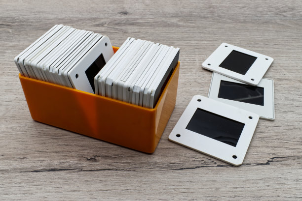 塑料盒子里的旧幻灯片。木桌上的老式35毫米胶片。图片下载