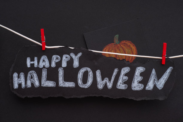 挂在晾衣绳上的黑纸上写着“万圣节快乐”几个字图片下载
