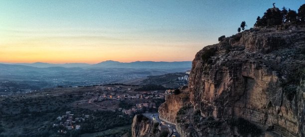 在阿尔及利亚的君士坦丁，日落时一条路穿过岩石山图片下载
