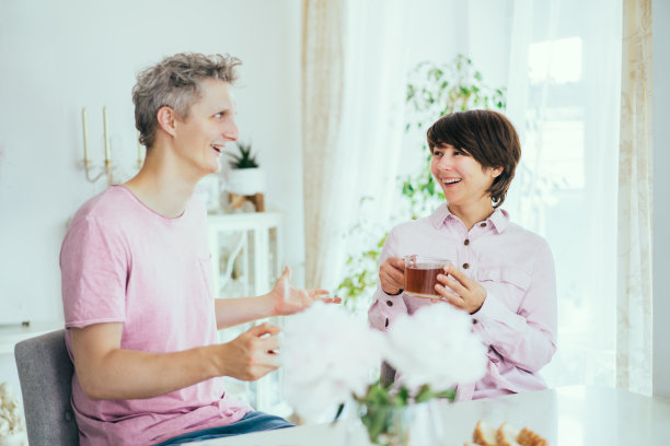年轻的男人和女人在家庭厨房里动情地讨论着什么。夫妻一起吃早餐，一起玩。家庭时间。图片下载