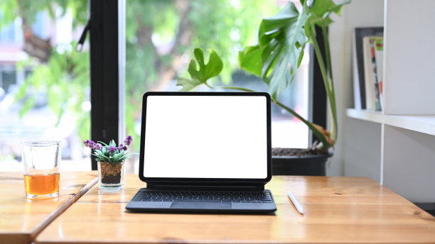 在木桌上模拟带有无线键盘的电子平板电脑。图片下载