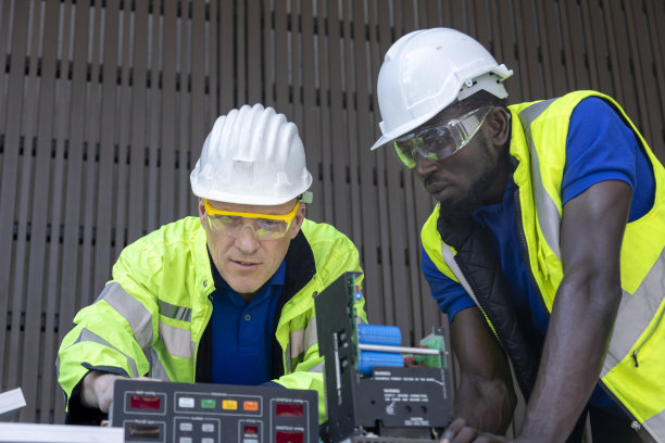 一名白人和非裔美国工程师正在为可持续能源建立太阳能电池板电路图片下载