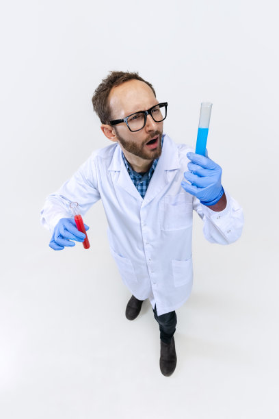 年轻的化学家，博士在白色背景下进行化学研究的高角度视角。药理学的概念。图片下载