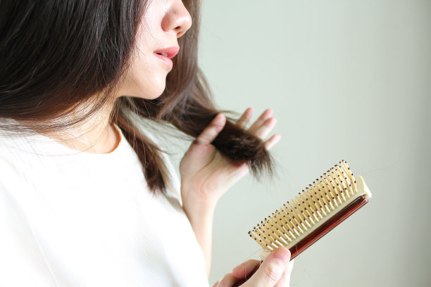 亚洲妇女在梳头时担心自己的脱发图片下载